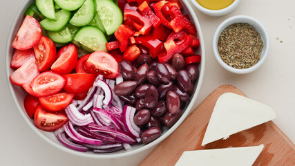 Ingredients for classic Greek salad and feta cheese on cutting board