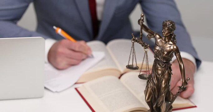 impressive statue with a balance and a sword and a businessman working in the background