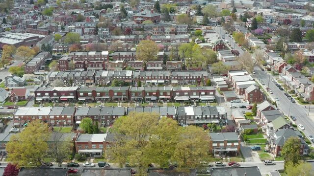 Aerial of urban city in USA. Rows of homes during spring. Blooming trees highlight residential district scene.