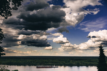 Fototapeta na wymiar barge on the river under the sky with clouds
