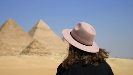 Female Tourist With Purple Hat Looking At The Great Pyramid Of Giza In Cairo, Egypt At Sunny Day. - Close Up, Orbiting