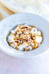Ravioli with garlic and yoghurt on a white wooden background
