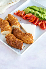 Breakfast plate on a white background. Served with sesame bagel, tomato, cucumber and cheese