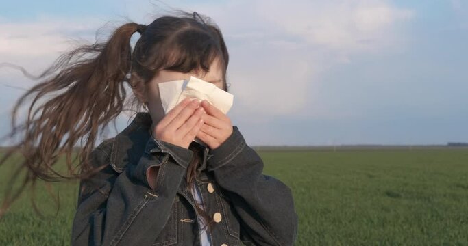 Summer allergy with cough. A sick little girl cough in the green summer field in the day light.