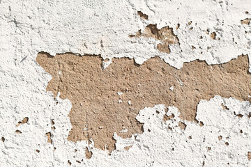 Old grunge background with white peeling plaster on stone wall