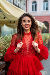 beautiful stylish brunette woman posing in red dress