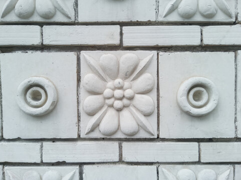 The textured wall is lined with decorative ceramic tiles with image of flowers.