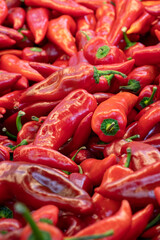 fresh red peppers in the market. red pepper in bulk. ripe red peppers in a street market. capia pepper.