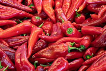 fresh red peppers in the market. red pepper in bulk. ripe red peppers in a street market. capia pepper.