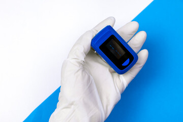 Doctors hand in white medical latex gloves hold pulse oximetry. Noninvasive and painless oxygen saturation level test. Part of set.