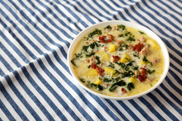 Homemade Zuppa Toscana with Kale and Bread in a white bowl, low angle view. Copy space.