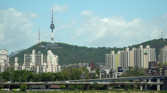 Namsan Seoul Tower, Cars traffic on bridge, Yongsan-ru apartments and villas panorama from far point on sunny and cloudy day