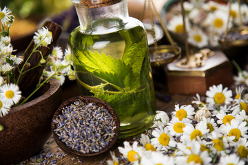Fresh herbs and oil, wooden table background