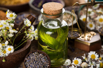Fresh herbs and oil, wooden table background