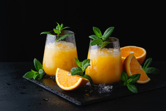 Cold summer orange lemonade with mint and ice in a glass. Copy Space for text