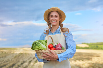 Woman farmer straw hat apron standing farmland smiling Female agronomist specialist farming agribusiness Happy positive caucasian worker agricultural field