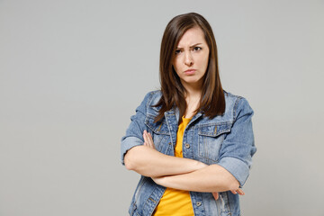 Young frowning serious shrewd caucasian woman 20s wear casual denim jacket yellow t-shirt looking...