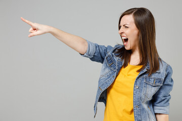 Young angry furious caucasian woman wear casual denim jacket yellow t-shirt point index finger...