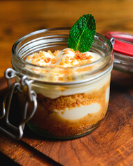 Fruit layered dessert with fresh mint in a small jar. Eating out concept, healthy food, sweet dessert