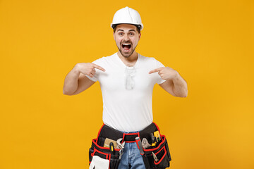 Young shocked employee handyman man in protective helmet hardhat point index finger himself isolated on yellow background. Instruments accessories for renovation apartment room. Repair home concept