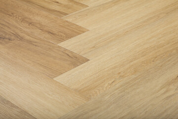 Laminate and parquet with herringbone background. Wooden floor with a chevron pattern in the living...