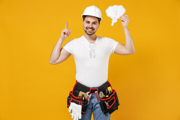 Young employee handyman man in protective helmet hardhat hold say cloud with lightbulb point finger up new idea isolated on yellow background Instruments renovation apartment room Repair home concept