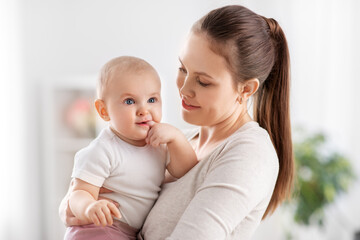 family, motherhood and people concept - happy mother with little baby daughter at home