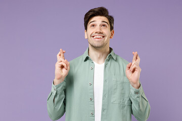 Young caucasian man in mint shirt white t-shirt waiting for special moment, keeping fingers...
