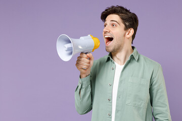 Young fun expressive excited happy caucasian man 20s wearing casual mint shirt white t-shirt scream in megaphone shout hot news isolated on purple background studio portrait People lifestyle concept