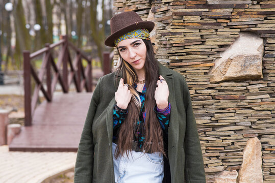 Portrait of a beautiful and stylish hippie girl in a hat on the street