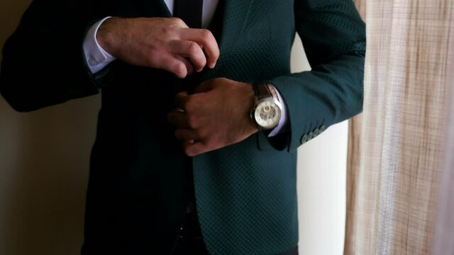 Stylish man in a fashion jacket preparing to go out at a reception or wedding. 
