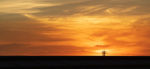 Background of outdoor blue sky, sunset light and clouds in evening with landscape of urban city tele communication pole and blank copy space.