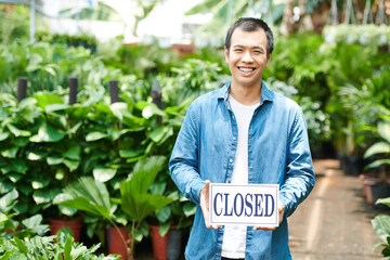 Excited young man closing gardening center after big sale