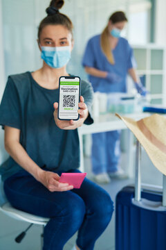 Woman holding digital covid-19 vaccine passport on her smart phone