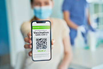 Close up of hand holding phone with digital vaccination card