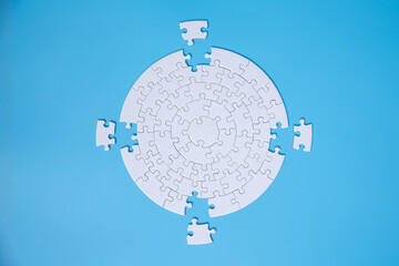 White jigsaw puzzle pieces on a blue background. Problem solving concepts. Texture photo with copy...