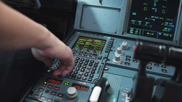 Pilot's hand controls the modern airplane. Pilot inputting parameters to the computer of airplane. The MCDU system of airplane-Airbus system.4K