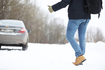 Man and car. Winter walk and car repair.