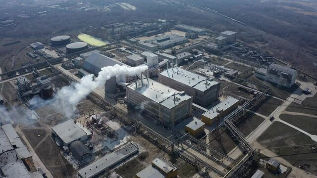 Pipe factory smoke. Aerial survey. Emission to atmosphere from industrial pipes. Smokestack pipes shooted with drone. Aerial view of industrial area with chemical plant. Smoking chimney from factory.