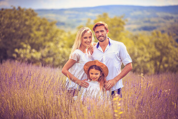 Naklejka na ściany i meble Portrait of smiling family in lavender field.