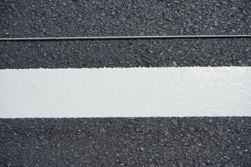 Fototapeta premium Technicians are marking a traffic line on a paved road.