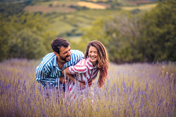 Young couple having fun on lavender field.