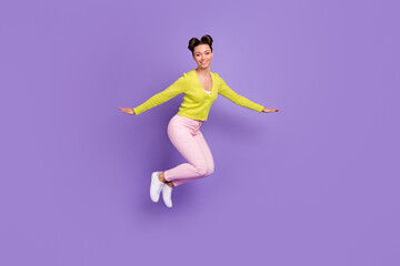 Fototapeta na wymiar Full size photo of young pretty charming lovely happy smiling positive girl jumping isolated on violet color background