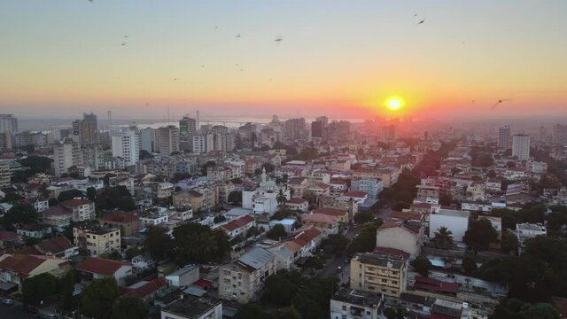 Aerial view of the cityscape of Maputo city, colorful sunset, in Mozambique - tracking, drone shot