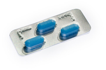 Blister pack with blue pills on a white background, close-up