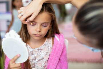 Little girl having a make up time.