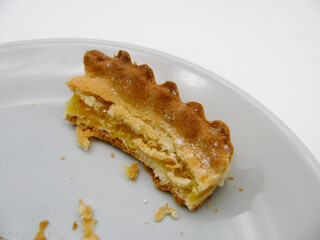 Leftovers from a piece of baked pie on a gray plate. Food stubs.