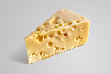 Piece of cheese triangular in shape, with large holes