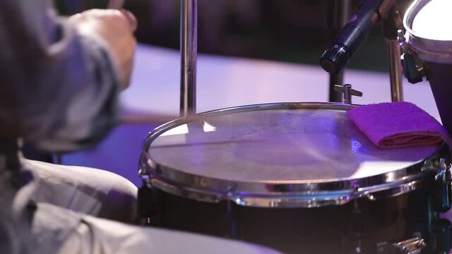 Drummer playing drum sticks on a snare drum in dark