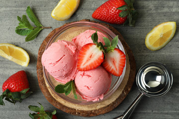 Bowl with ice cream balls and ingredients on gray textured background
